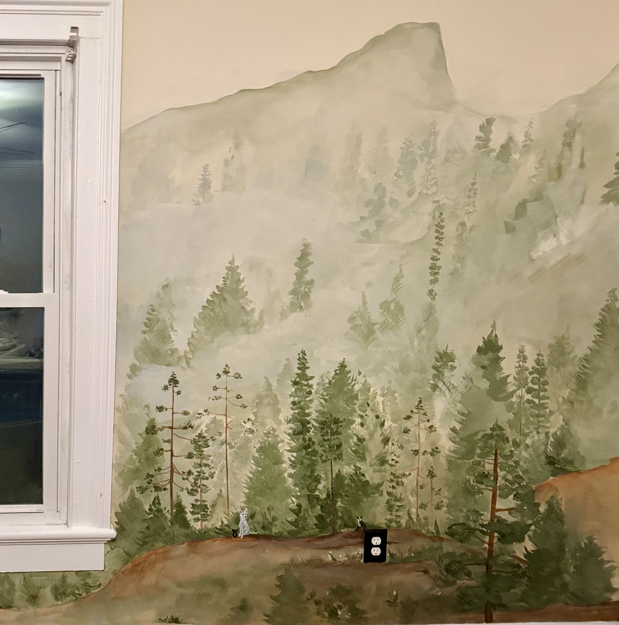 Misty forest mural painted around a window, pines fading into fog