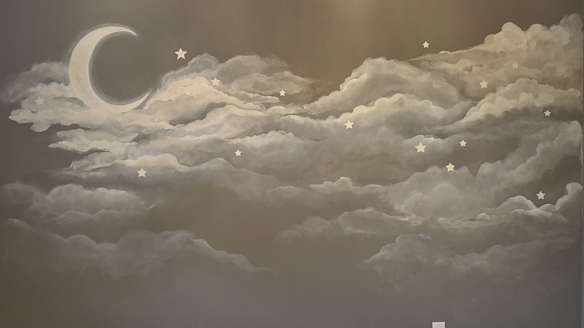 Hand-painted crescent moon, sixteen stars and billowing clouds across a nursery wall in Fort Mill, SC, in soft greys and white